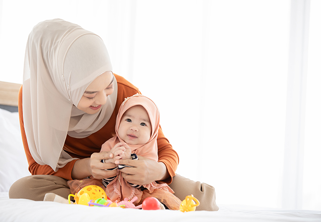 Mother and infant daughter in headscarves.